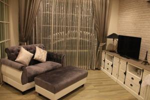 uma sala de estar com um sofá e uma televisão em Summer Hua Hin By Sirirat em Hua Hin