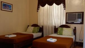 a room with two beds with towels on them at RF ANICETO MANSION in Vigan