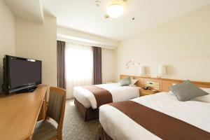 Кровать или кровати в номере Osaka Tokyu REI Hotel