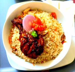 una ciotola di cibo con carne e riso su un tavolo di Hotel krish a Kalkudah