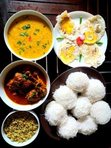 Hotel krish في كالكوداه: مجموعة من أربعة أطباق من الطعام مع الأرز