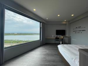 um quarto com uma grande janela com vista para a água em H Suite Sea em Lukang