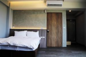 1 dormitorio con 1 cama grande y puerta de madera en H Suite Sea, en Lukang