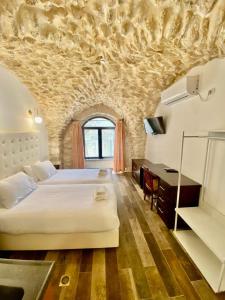 sypialnia z dużym białym łóżkiem i biurkiem w obiekcie Petrakis Inn w Jerozolimie