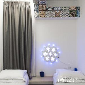 Cette chambre dispose d'un miroir éclairé sur le mur. dans l'établissement B&B Copacabana Colors, à Margherita di Savoia