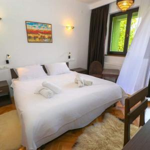 a large white bed in a room with a window at Holiday Resort Zlatni Dol Mostar in Goranci