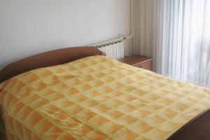 a bed with a yellow comforter in a bedroom at Apartments by the sea Fazana - 7192 in Fažana