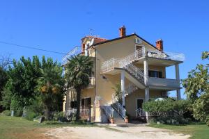 a large house with stairs on the side of it at Apartment Basanija 7149b in Savudrija