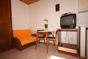 a small living room with a table and a tv at Apartments by the sea Fazana - 7192 in Fažana