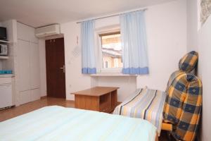 a small bedroom with a bed and a window at Studio Basanija 7148a in Savudrija