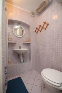 a bathroom with a white toilet and a sink at Studio Basanija 7148a in Savudrija
