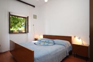 a bedroom with a bed with a blue blanket and a window at Apartment Basanija 7149b in Savudrija