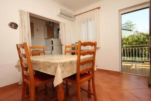a kitchen and dining room with a table and chairs at Apartment Basanija 7149b in Savudrija