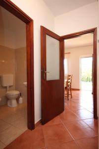 bagno con servizi igienici e porta in legno di Apartment Basanija 7149b a Savudrija