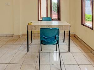 - un bureau en bois avec une chaise bleue dans l'établissement OYO 91636 Kak Dadut Homestay, à Batam Center