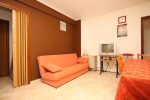 a living room with an orange chair and a television at Apartments with parking space Fazana - 7153 in Fažana