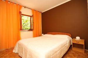 a bedroom with an orange bed and a window at Apartments with parking space Fazana - 7153 in Fažana