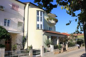 biały dom z balkonem na ulicy w obiekcie Apartments with a parking space Umag - 7147 w mieście Umag