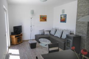 ein Wohnzimmer mit einem Sofa und einem TV in der Unterkunft Family friendly seaside apartments Novigrad - 7118 in Novigrad Istria