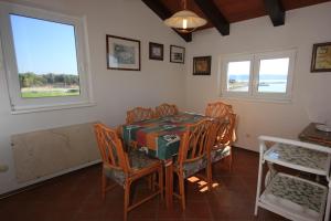ein Esszimmer mit einem Tisch, Stühlen und Fenstern in der Unterkunft Family friendly seaside apartments Novigrad - 7118 in Novigrad Istria