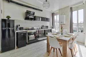 eine Küche mit einem Tisch und einem Esszimmer in der Unterkunft Appartement Cosy Bourgoin - Gare & Centre in Bourgoin