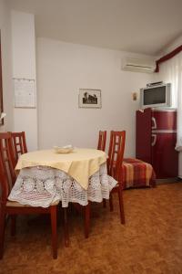 a room with a table and chairs and a refrigerator at Apartments with a parking space Novigrad - 7121 in Novigrad Istria
