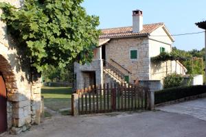 a stone house with a gate and a fence at Family friendly house with a swimming pool Sveti Petar u Sumi, Central Istria - Sredisnja Istra - 7092 in Sveti Petar u Šumi