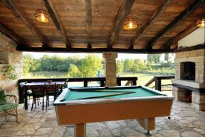 a pool table on a patio with a fireplace at Family friendly house with a swimming pool Sveti Petar u Sumi, Central Istria - Sredisnja Istra - 7092 in Sveti Petar u Šumi
