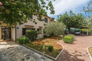 a building with a courtyard in front of it at Apartments with a parking space Kukci, Porec - 7166 in Nova Vas