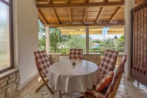 a table and chairs on a porch with a window at Apartments with a parking space Kukci, Porec - 7166 in Nova Vas