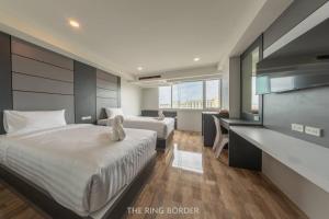 a hotel room with two beds and a desk at The Ring Border in Ban Khlong Phruan