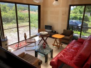 a living room with a red couch and a table at Cool-Villa 飛騨リゾート in Hida