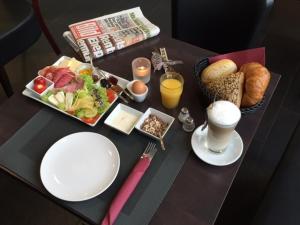 einen Tisch mit einem Tablett mit Lebensmitteln und einem Teller mit Lebensmitteln in der Unterkunft Tankbar's Hotelchen in Heroldsberg