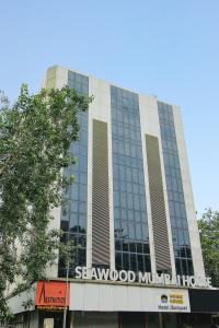 a building with a sign on the front of it at Hotel Mumbai House Juhu, Santacruz West, Mumbai in Mumbai