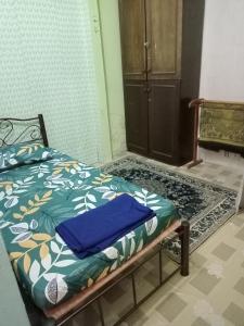 Schlafzimmer mit einem Bett mit blauer Bettwäsche und einem Schrank in der Unterkunft FirZan Homestay Bukit Mahkota in Kajang