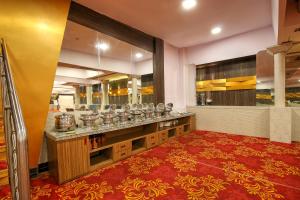 Hotel Mumbai House Juhu, Santacruz West, Mumbai في مومباي: a room with a counter with aasteryasteryasteryasteryasteryasteryasteryastry