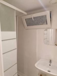 a white bathroom with a sink and a mirror at Superbe logement(B) avec Parking Gratuit sur place in Drancy