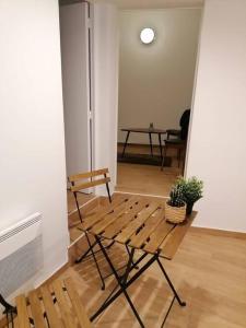 une chambre avec un banc en bois et une table dans l'établissement Superbe logement(B) avec Parking Gratuit sur place, à Drancy