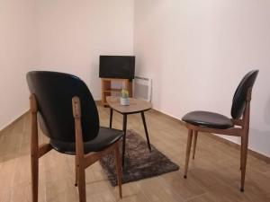 a room with two chairs and a table and a television at Superbe logement(B) avec Parking Gratuit sur place in Drancy