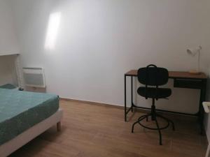 a bedroom with a desk and a chair next to a bed at Superbe logement(B) avec Parking Gratuit sur place in Drancy