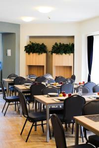 un comedor con mesas, sillas y plantas en Amelia Zdroj Medical & Spa, en Iwonicz-Zdrój