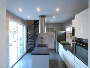 a kitchen with a spiral staircase in the background at Maison moderne et spacieuse avec piscine in Villeurbanne