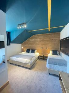 een slaapkamer met 2 bedden en een blauw plafond bij Hotel La Verticale in Chamonix-Mont-Blanc