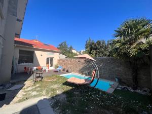 un patio trasero con piscina y una casa en Maison moderne et spacieuse avec piscine, en Villeurbanne