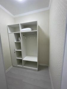 a white closet with white shelves in a room at Апартаменты гостиничного типа в центре города ЖК Арман in Aktobe