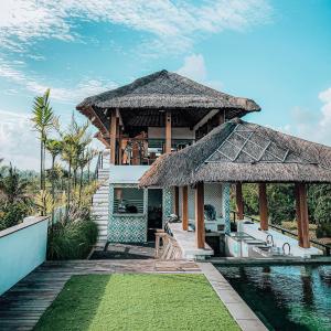 a villa with a swimming pool and a resort at Swell Hotel, Pool Bar & Restaurant in Tanah Lot