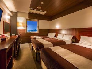 a hotel room with two beds and a television at Tokai City Hotel in Tokai