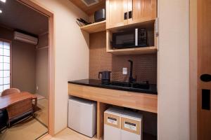 una pequeña cocina con encimera y microondas en Rinn Tsukinowa, en Kioto