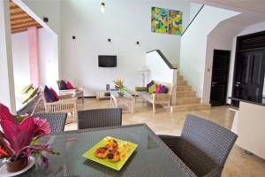 5 Bedroom Holiday Villa - Kuta Regency B8 في كوتا: غرفة معيشة مع طاولة مع طبق من الطعام