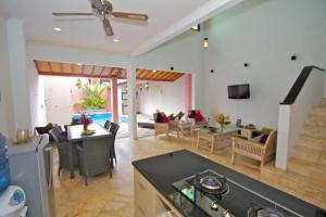 5 Bedroom Holiday Villa - Kuta Regency B8 في كوتا: غرفة معيشة مع مطبخ وغرفة طعام